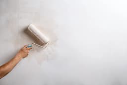 Application de peinture sur un mur, travaux de finition et ravalement